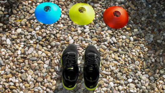 Drei verschiedenfarbige Markierungsteller und Handballschuhe